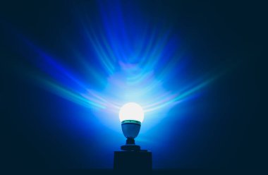 Yerde duran çok güzel bir gece lambası. Duvarlarda mavi gölgeler.