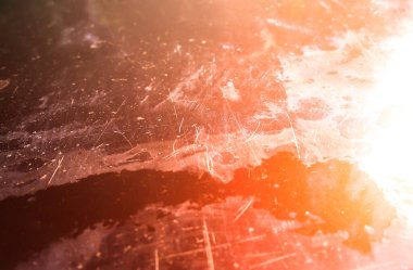 Kaputunda çizikler olan eski bir araba. Araçta soyulmuş boya..