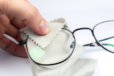 Okuma gözlüğünü bezle temizleyen kadın. Fotoğrafı kapat..