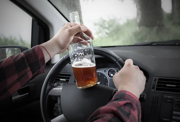 Drunk driver behind the wheel. Man drinking in the car. Alcohol problem. Dangerous problem. Accident possibility.