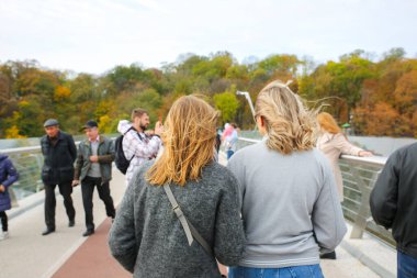 KYIV, UKRAINE - 12 Ekim 2019: Halkın Dostluk Kemeri 'nin yakınındaki Kyiv köprüsünde görüş. Ukrayna 'nın sonbahar başkenti. Fotoğraf çeken turistler.