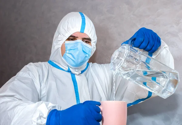 Doctor wearing medical protective suit, mask, and gloves pouring water for the test. Protection mers by virus epidemic. Coronavirus (COVID-19). Healthcare concept.