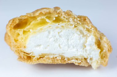 Beyaz tabakta kremalı kek. Kahvaltıda tatlı. Kesilen pastanın yarısının görüntüsünü kapat.