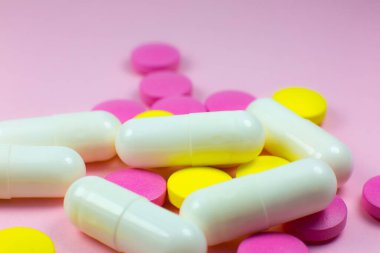 Pembe arka planda renkli haplar ve haplar. Kapatın. Tıbbi tedavi kavramı.