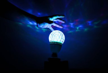 Gece lambasının üzerinde el ele tutuşan adam. Duvarlarda mavi gölgeler var. Ruhani falcılık konsepti.