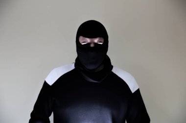 Koyu renk elbiseli hırsız. Maskeli tehlikeli bir soyguncu. Suçlu adam..