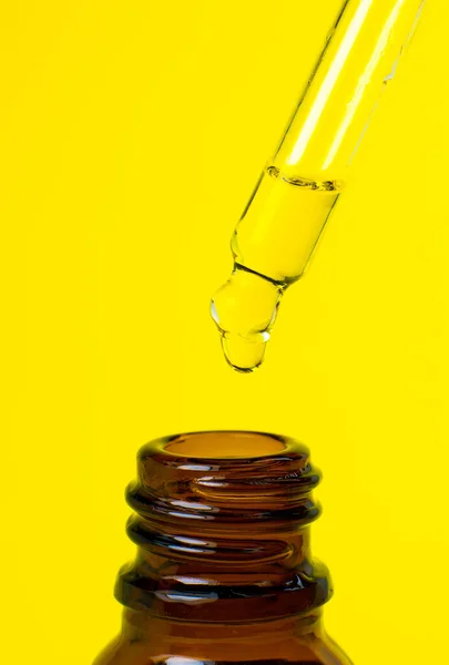 Garrafa Óleo Cosmético Com Uma Pipeta Fundo Amarelo Fechar Gotejamento — Fotografia de Stock