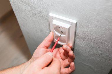 Adam soketi takıyor. Dairede elektrik bakım onarımı yapılıyor. İçerideki restorasyon.