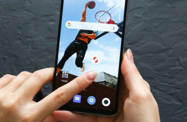 LVIV, UKRAINE - 30 Ekim 2019: Modern akıllı telefon ekranında Shutterstock katılımcı uygulama simgesi seçen bir akıllı telefon kullanıcısı