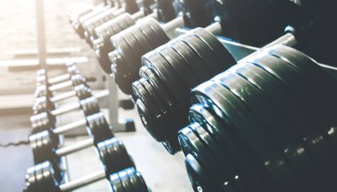 Spor salonundaki çiğ dambıllar. Fitness sporu motivasyonu. Sağlıklı yaşam tarzınız kutlu olsun. Çubuk ağırlıklarıyla egzersiz.