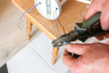 Adam elinde kerpeten tutuyor. Lamba kurulumu. Ampul için elektrik yalıtkan. İçerideki restorasyon.