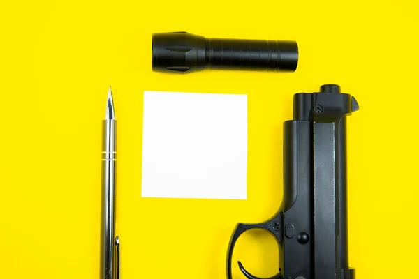 Black Gun Reminder Note Paper Pen Flashlight Lies Yellow Background — Stock Photo, Image