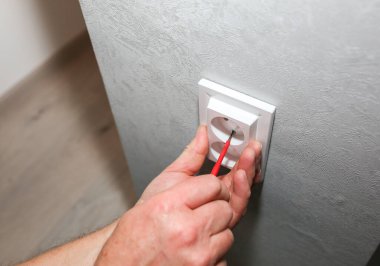 Adam soketi takıyor. Dairede elektrik bakım onarımı yapılıyor. İçerideki restorasyon.