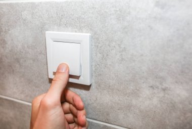 Adam ışıkları kapatıyordu. Beyaz duvarda yeni prizler var. Tadilattan sonra detaylar. Dairedeki restorasyon süreci.