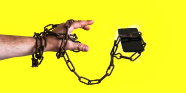 Akıllı telefonun etrafındaki paslı zincirler. Sarı arka planda izole edilmiş. Telefon havada uçuşuyor. Modern teknolojilere bağımlı..