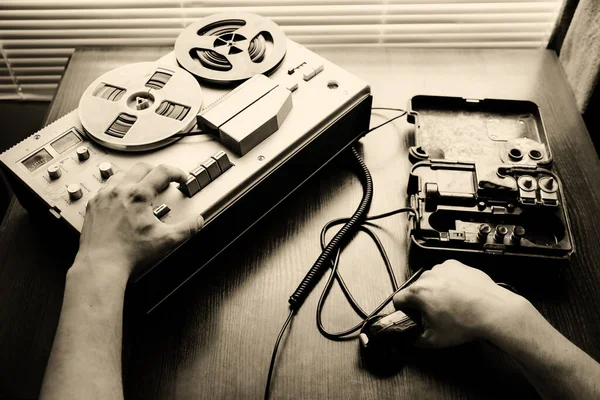 Special agent holds field telephone set USSR. Officer wiretapping   on the reel tape recorder. KGB spying conversations.