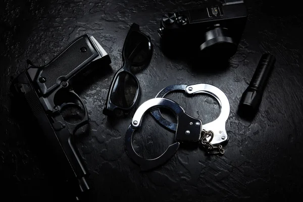 Schwarze Pistole Taschenlampe Brille Kamera Und Polizeihandschellen Liegen Auf Dem — Stockfoto