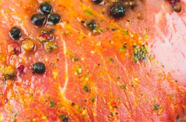 Baharatlı çiğ domuz eti ve yeşil biberiye. Kırmızı et dokusu arka plan, ham jambon. Makro fotoğraf. Yağlı, sulu biftek..