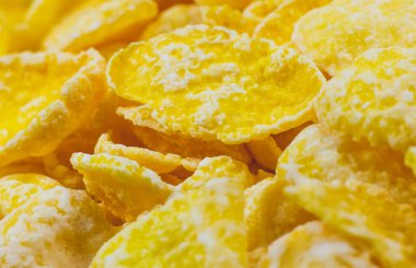 Sarı mısır gevrekleri yakın çekim fotoğrafı, yiyecek dokusu arka planı, üst manzara. Makro atış. Mükemmel kahvaltı..