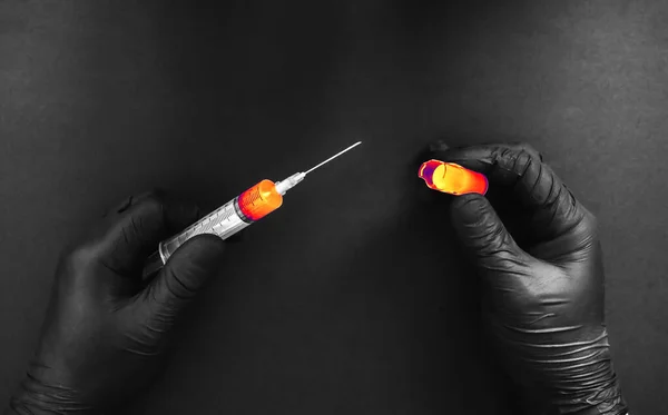 男人从断掉的安培剂中注射了一针低质量的医疗 黑色手套使用药物的注射器 — 图库照片