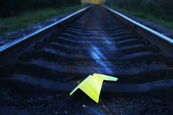Plano Papel Amarelo Feito Mão Deitado Nos Trilhos Ferroviários Fotografia — Fotografia de Stock