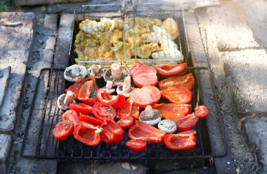 Açık ateşte barbekü. Tatlı biber, mantar ve domates. Tavuk kızartması..