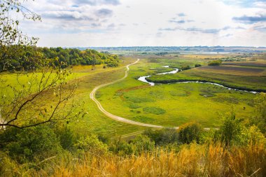 Tepeden sonbahar tarlası. Doğadaki yol. Nehirli güzel bir manzara.