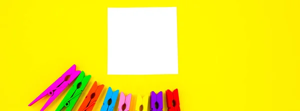 노란색 배경에는 색상의 나무로 Clothespins 미니멀리즘 독창적 창의적 스마트폰 페이퍼 — 스톡 사진