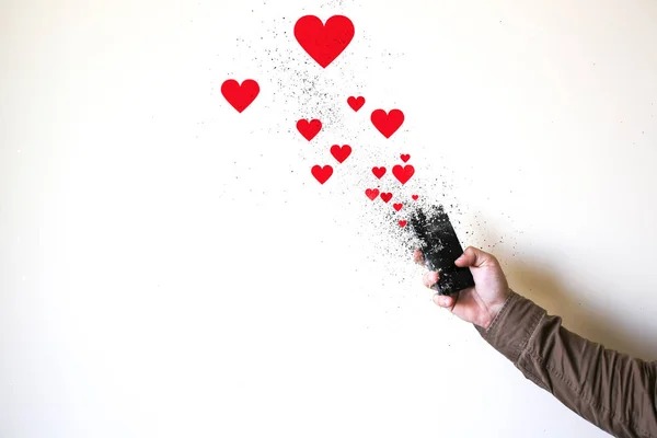 Man is holding smartphone in hands isolated on white background. Smartphone falling into pieces. Hearts and likes from social networks. Addicted to technologies.