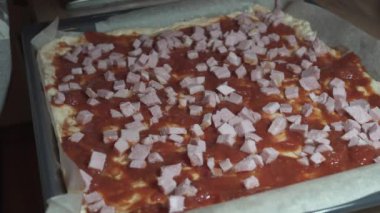 Kadın ev yapımı pizza hazırlıyor, peynir, jambon, mantar, mozzarella ve domates sosu ekliyor. Sağlıklı yiyecekler. İtalyan mutfağı. Lezzetli bir kavram. Evde yalnızlık yemeği..