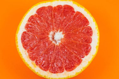 Turuncu arka planda greyfurt dokusu var. Citrus yakın çekim fotoğrafı. Sağlıklı yiyecekler. Harika duvar kâğıdı. Vejetaryen ve vejetaryen kavramı. Doğadan gelen vitaminler. Minimalizm, orijinal güzel fotoğraf.