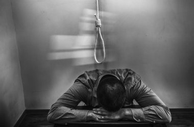 İlmek ofis çalışanının üstünde. İntihar konsepti. İş stresi yüzünden asılmış. Bitkinlik bunalımı. Korkunç bir hayat durumu. Masadaki dizüstü bilgisayarın yanında biri var..