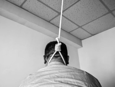 Boynuna ilmik geçirilmiş bir ofis çalışanı. İntihar konsepti. İş stresi yüzünden asılmış. Bitkinlik bunalımı. Korkunç bir hayat durumu. Siyah beyaz fotoğraf.