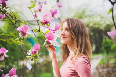 Çiçek açan ağacın yanında güzel bir kız. Açık havada manolya çiçeği. Bahar havası. Kadın dinleniyor..
