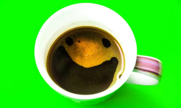 緑の背景に隔離された泡から笑顔でコーヒー 面白い写真 — ストック写真