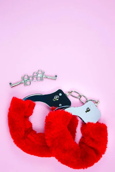 红色性感蓬松的手铐 有粉红色背景的钥匙 — 图库照片