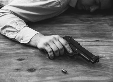 Ofis çalışanı elinde silahla yerde yatıyor. İş stresi yüzünden intihar. Depresyon ya da tükenme. Korkunç bir hayat durumu. Masadaki dizüstü bilgisayarın yanında biri var..