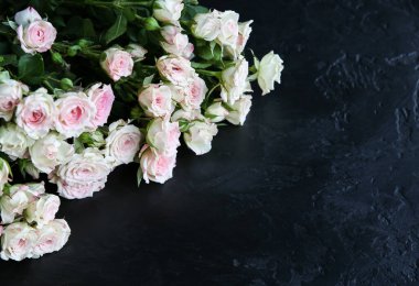 Siyah arka planda güzel çiçekler. Gül buketi. Mükemmel düzüşme. Annemin tatil kartpostalı kutlu olsun. Uluslararası Kadınlar Günü selamı. Reklam veya tanıtım için şık bir fikir.