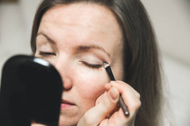 Kız makyaj yapıyor. Fırçayla göz farı. Güzellik fotoğrafı konsepti.