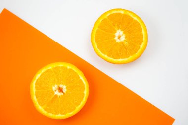 Beyaz ve turuncu arka planda Orange Fruit 'un yakın plan fotoğrafı. Citrus ikiye bölünmüş, içeride, makro manzaralı. Minimalizm, orijinal ve yaratıcı bir imaj. Güzel doğal duvar kağıdı.