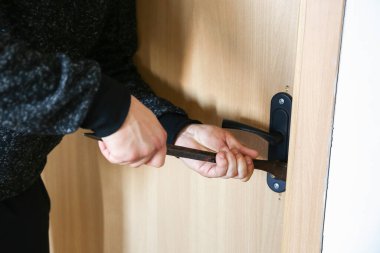 Kapının yanında demir levye olan bir suçlu. Hırsız eve giriyor..