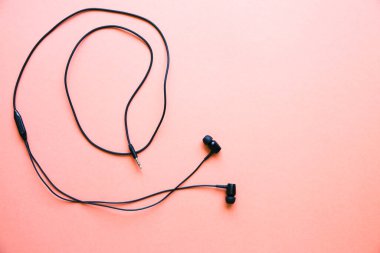 Pembe arka planda duran kulaklıklar. Modern müzik konsepti. Ses teknolojisi.