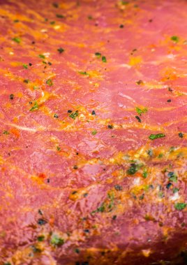 Baharatlı ve otlu çiğ domuz eti. Kırmızı et dokusu arka planda. Makro fotoğraf. Yağlı, sulu biftek..