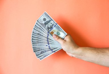 Adam elinde dolar banknotları tutuyor. Açgözlü dünyada para.