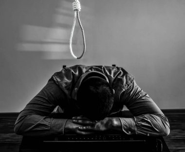 İlmek ofis çalışanının üstünde. İntihar konsepti. İş stresi yüzünden asılmış. Bitkinlik bunalımı. Korkunç bir hayat durumu. Masadaki dizüstü bilgisayarın yanında biri var..