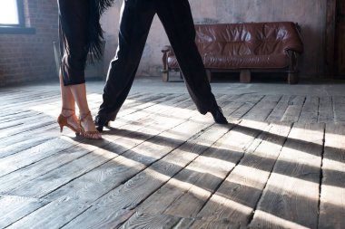 İki profesyonel balo dansçısının bacakları çatı katında dans ediyor. Ağır dumanla güzel bir sanat gösterisi. Spor hayatı konsepti. Tutku ve duygusal dans.