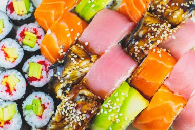 Renkli, değişik türde suşi seti. Japon usulü akşam yemeği. Sağlıklı yiyecekler. Filadelfia ve Maki suşisi yanında Avokado, Tuna, Somon, balık ve karides. Manzarayı kapat. Duvar Kağıdı.