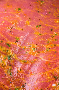 Baharatlı ve otlu çiğ domuz eti. Kırmızı et dokusu arka planda. Makro fotoğraf. Yağlı, sulu biftek..