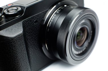 LVIV, UKRAINE - 20 Mart 2021: Siyah modern kamera Panasonic Lumix ve beyaz arka plan. Kapat..