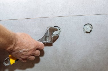 İşçi, banyo musluğu kurulumunu yapıyor. Dairede bakım onarımı var. Yenileme işlemi.